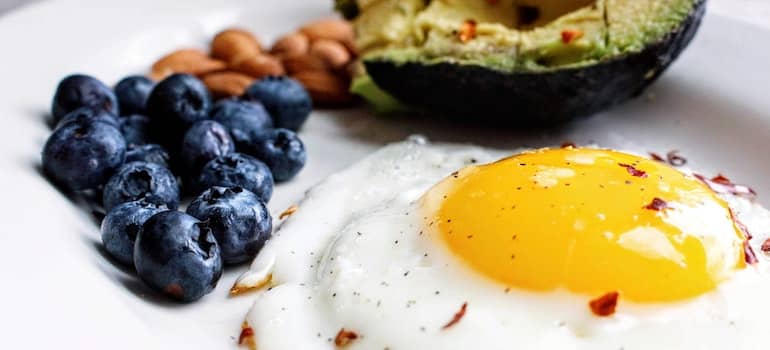 An egg, avocado, berries and nuts as a well-balanced breakfast