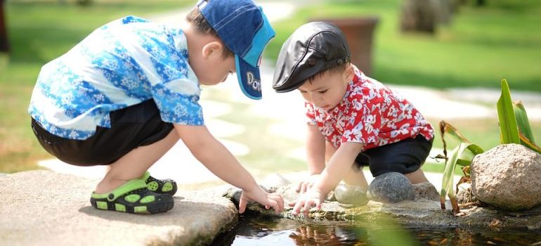 Two boys playing in a pond.