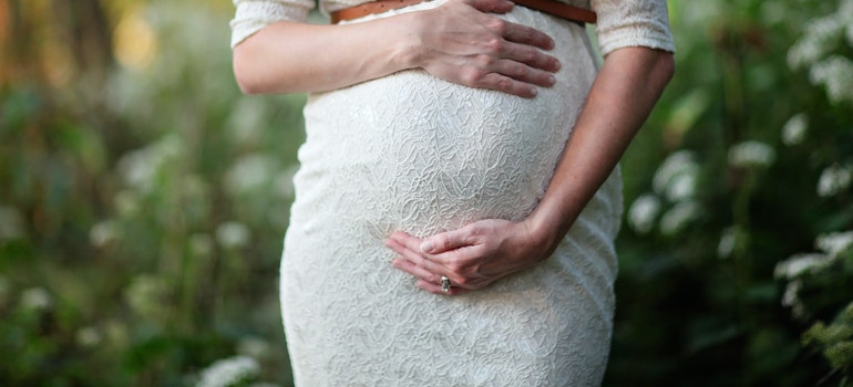 A healthy-looking pregnant woman holding her belly.