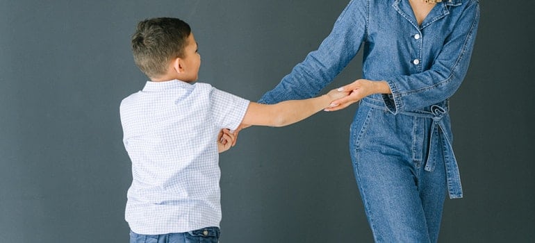 A kid and their mom are dancing.