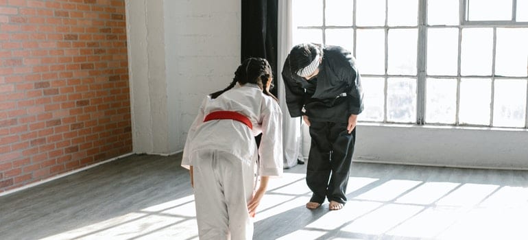 A kid and a teacher are practising karate.