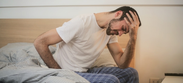 A man waking up in the morning with back pain