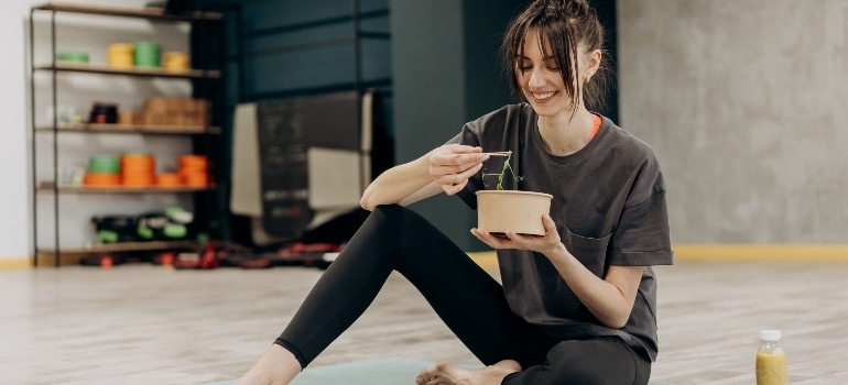 a woman eating and thinking how to calculate your nutrition needs