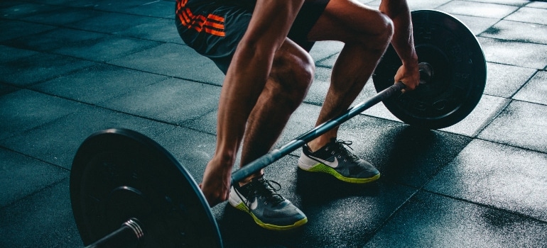 a man lifting weights in shoes for strength training