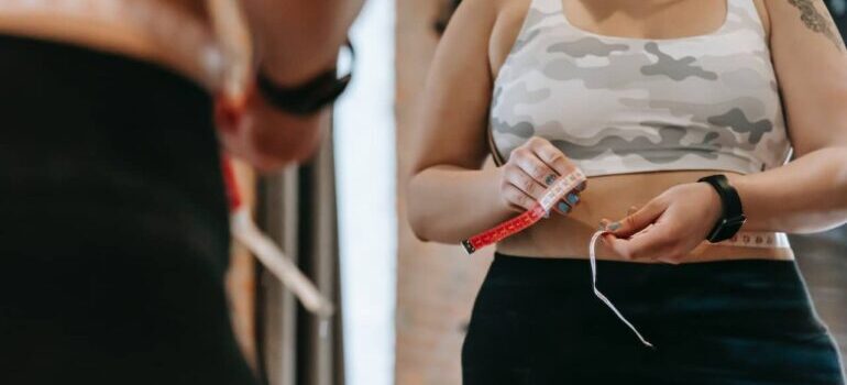 woman measuring waist before starting a low-fat diet