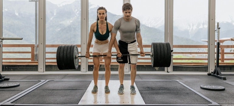 A man and a woman holding a loaded barbell
