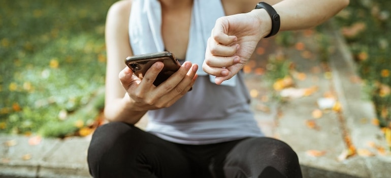 A woman is looking at her smart wristwatch.