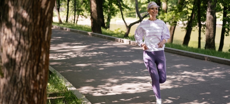 An elderly woman jogging in a park