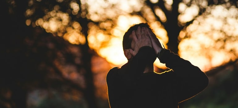 a man with hands over his head