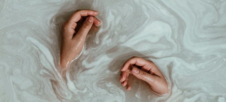 Person's hands in the water.