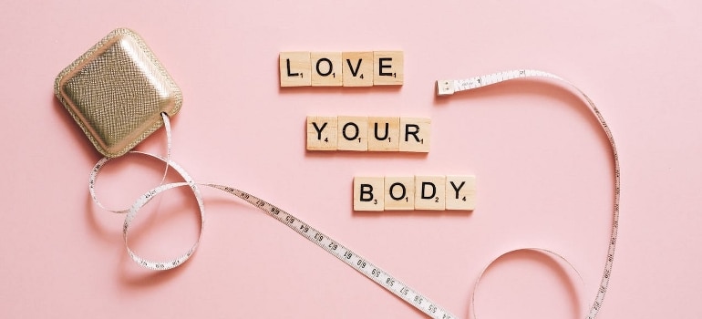 Motivation tiles that can help you get beach body ready on a pink background.