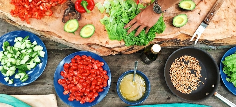 A person holding sliced vegetables.