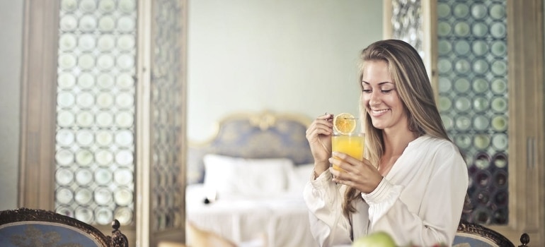 A cheerful woman enjoying breakfast after cold immersion therapy.