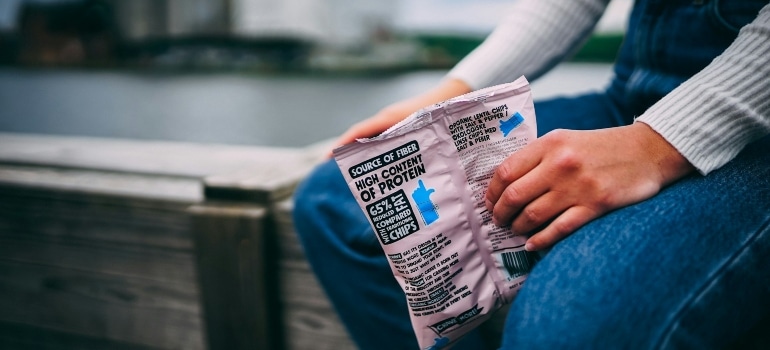 a person holding a bag of snacks thinking about the best tips for balanced snacking