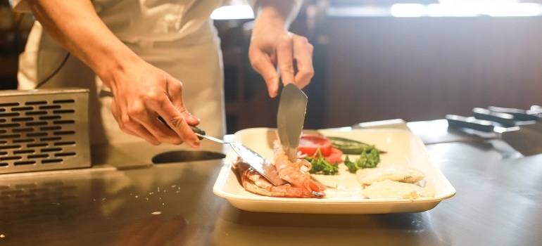 A chef is cooking in the kitchen in one of the top fitness-friendly restaurants and cafes in Dubai. 