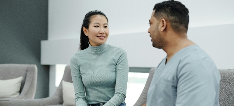 A healthcare provider at a clinic talking to a person about getting back to exercise after plastic surgery