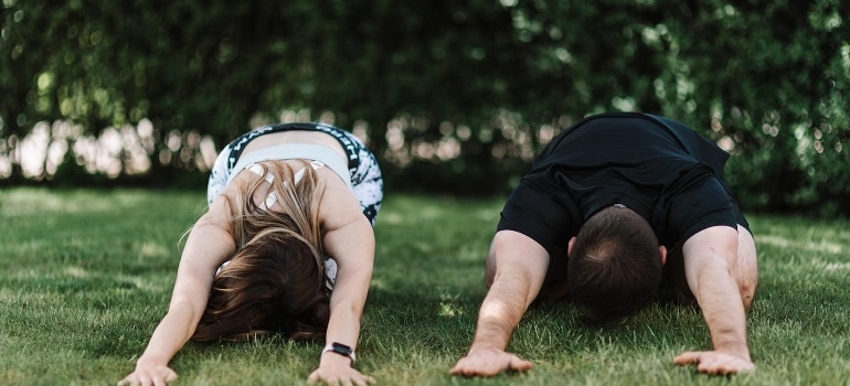 A couple doing yoga which is one of the top fitness challenges for couples in Dubai. 