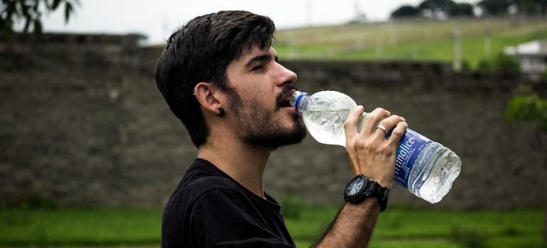 A man drinking water on a hot day.