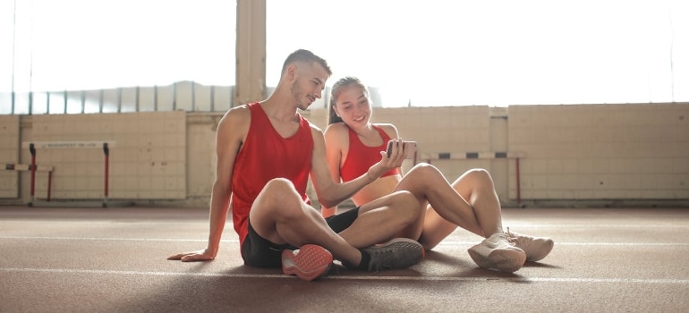A couple using a phone app to check their stats after running