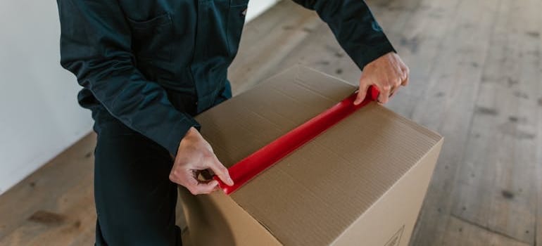 A person taping a box