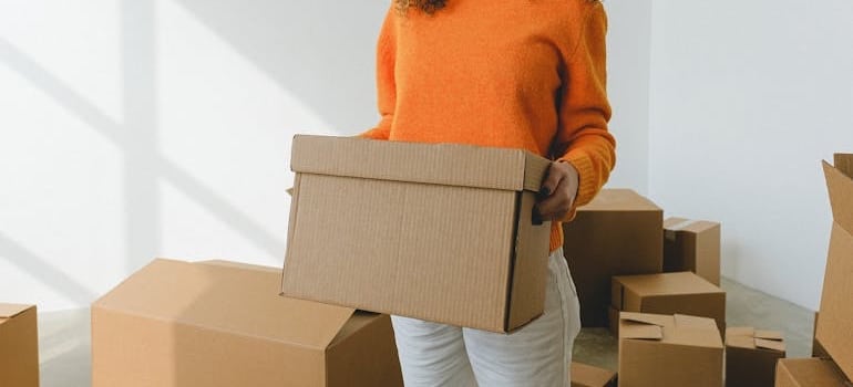 A person holding a box with fitness gear