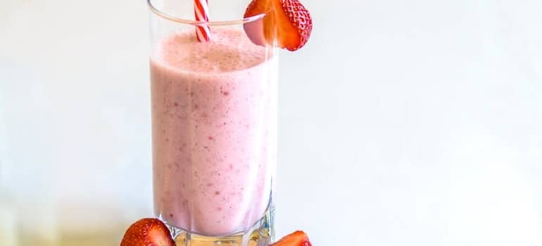 A glass filled with strawberry smoothie.