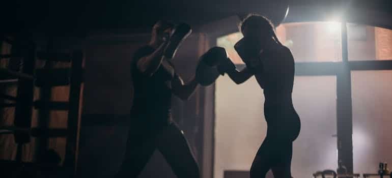 Woman practicing kickboxing with her coach.