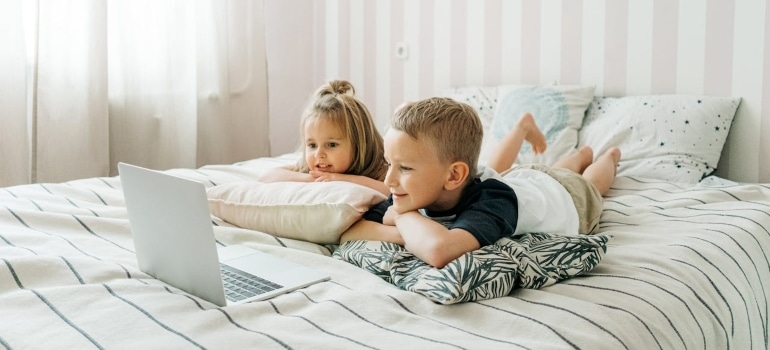 Children in bed watching something on laptop