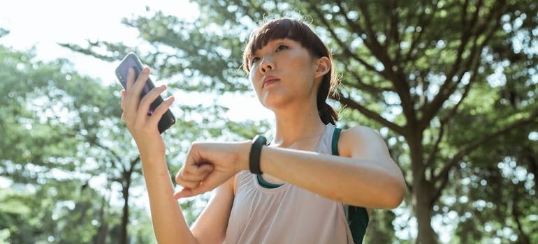 A woman tracking her workout with a fitness app and a fitness watch.