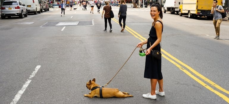 A woman walking her dog and laughing.