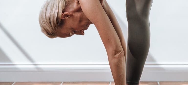 Woman touching her feet with her hands.