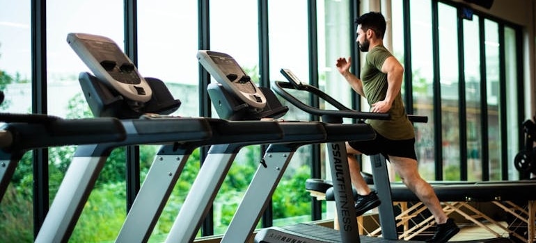 A man running on a treadmill in a gym, after reading one of the tips for living in Dubai