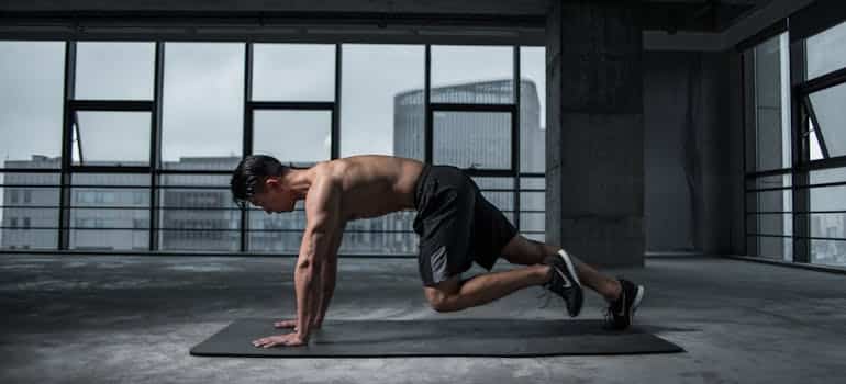 A man doing a plank thinking about how to overcome fitness plateau