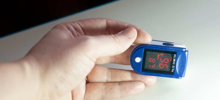 person checking his pulse and trying to identify overtraining and adjust your fitness program