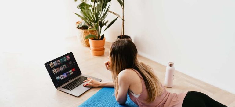 woman lying on floor and looking at laptop
