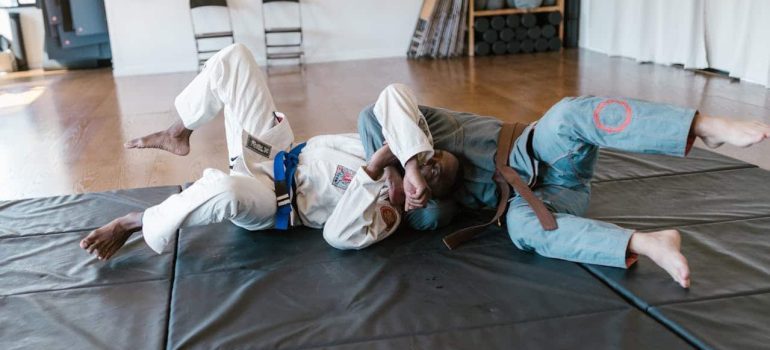 Two men lying on floor after learning about the benefits of self-defense