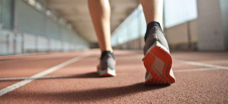 A fit runner standing on a racetrack in athletics arena