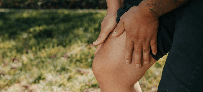 a person touching their knee to check if it's been injured