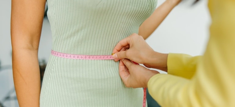 Person getting their waist measured