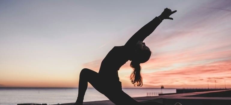 Person doing yoga as one of the types of workouts to try in Dubai if you're bored of the gym