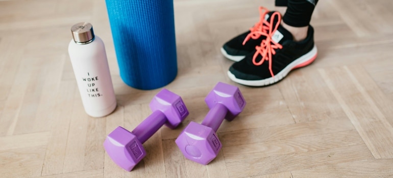 Purple dumbbells and a yoga mat