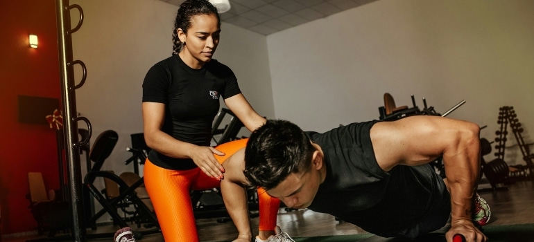 Person working out with the help of a personal trainer