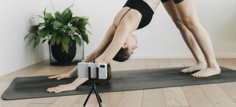 A woman is stretching out on the floor mat.