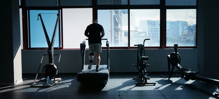 A man running on a treadmill in a gym, showing one of the Signs You Need to Change Your Workout Routine.