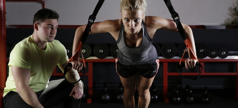 a girl doing exercises with a trainer