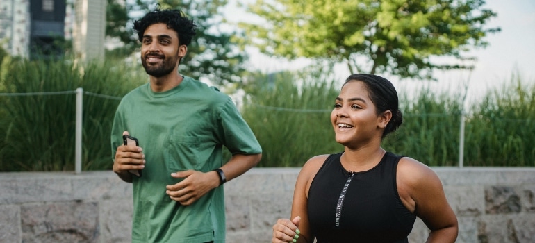 Couple running outdoors, looking comfortable and energized after acclimating to humid conditions