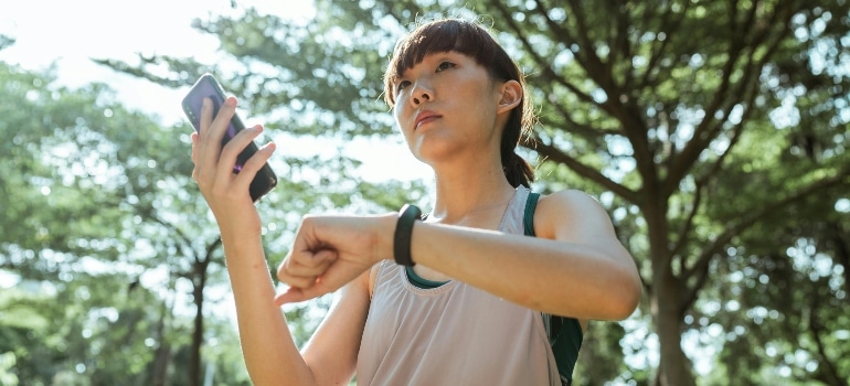 Woman tracking her fitness progress on a mobile app, monitoring recovery, energy, and workout results.