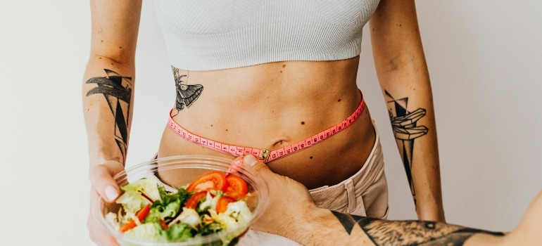 a girl measuring her waist