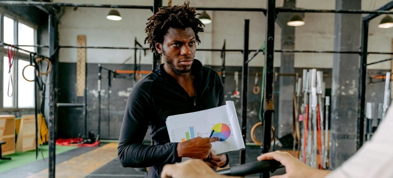 A personal trainer showing a client why some people gain weight when they start training.